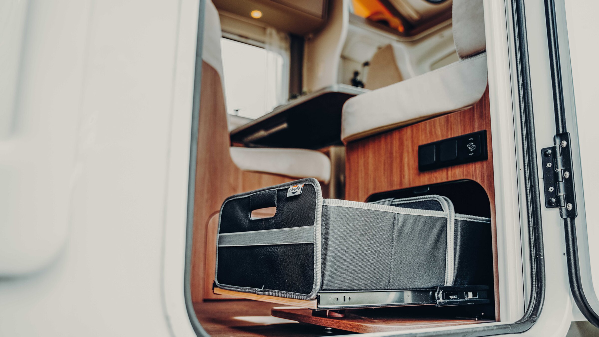 Carado motorhome interior with pull-out storage compartment in the entrance area