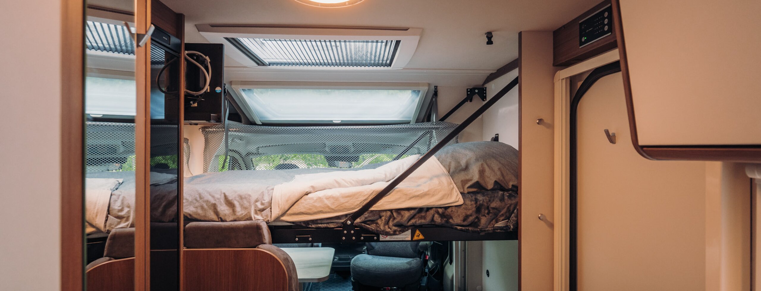 Carado motorhome interior with a drop-down bed above the cab and roof windows