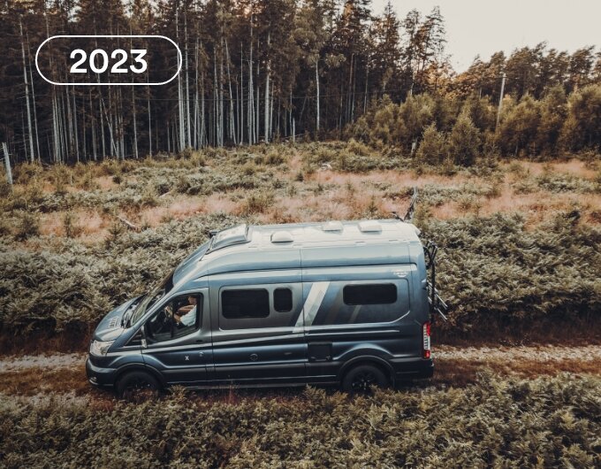 Carado motorhome camper van in side view on a country lane, surrounded by low scrub and woodland