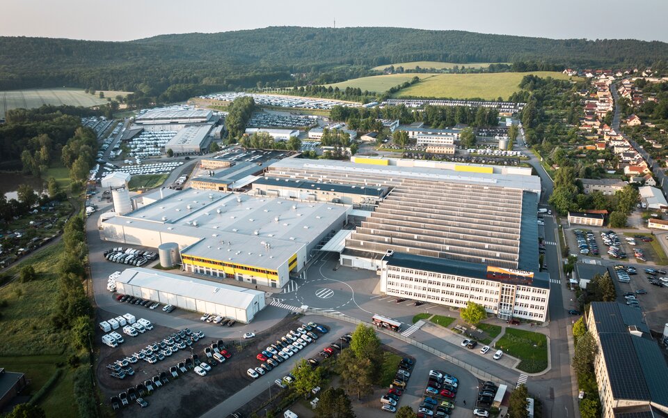 Aerial view of a motorhome factory site with halls, parking areas and parked Carado motorhomes