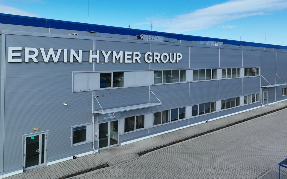 Facade of an Erwin Hymer Group industrial building with a large sign and entrance area