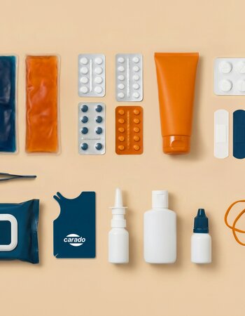 Open first aid kit with bandages, plasters, medication, scissors, a thermometer and a protective mask