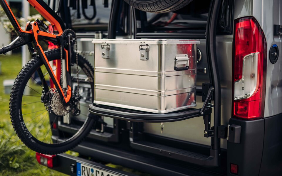 Rear section of a Carado motorhome with bike rack and pull-out aluminum storage box