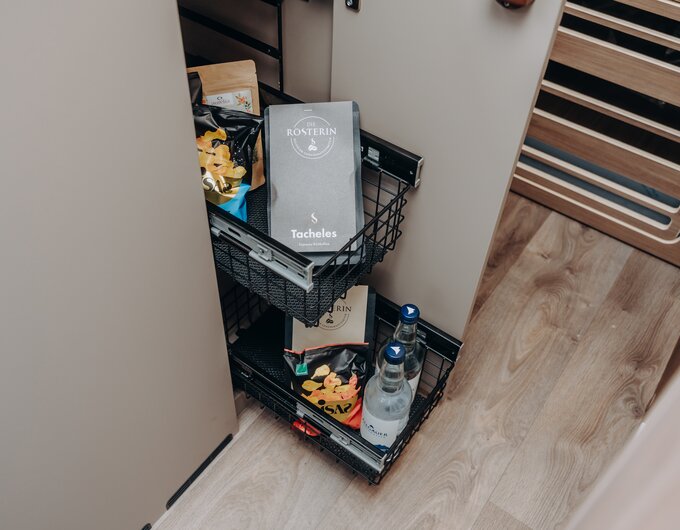 Pull-out wire baskets in your Carado motorhome, neatly packed with supplies, snacks and water bottles