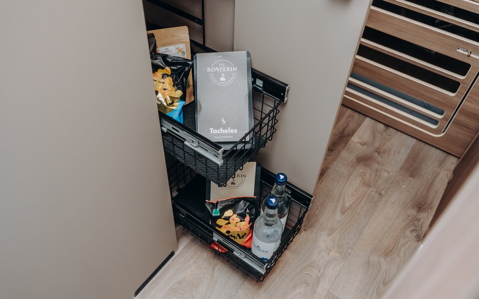 Pull-out wire baskets in your Carado motorhome, neatly packed with supplies, snacks and water bottles