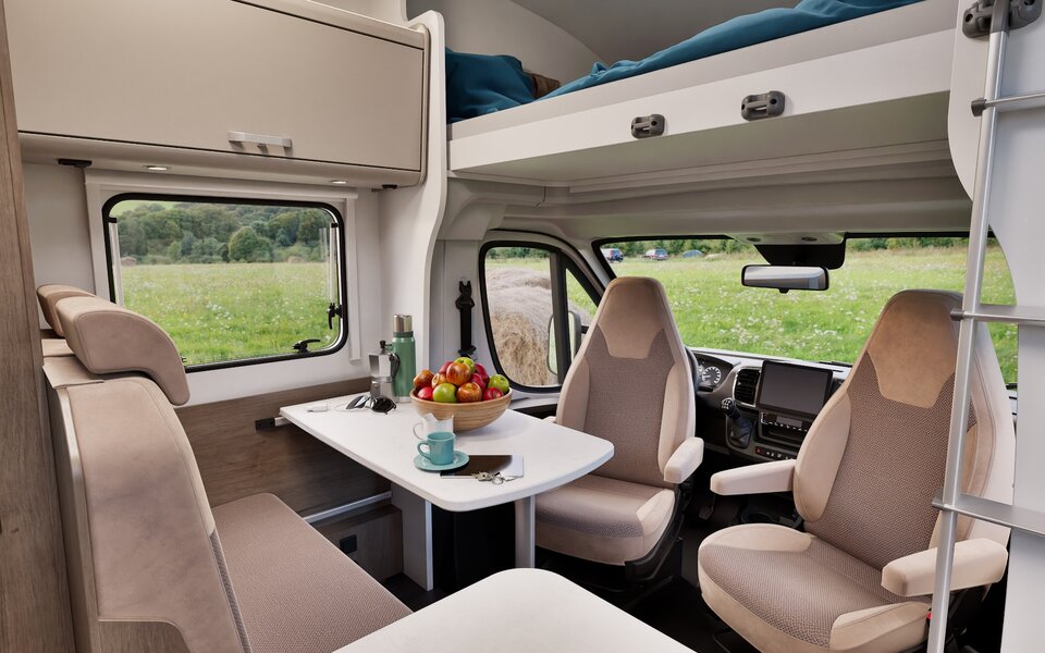 Carado motorhome interior with a dinette, swivel driver and passenger seats, and a drop-down bed above the cab