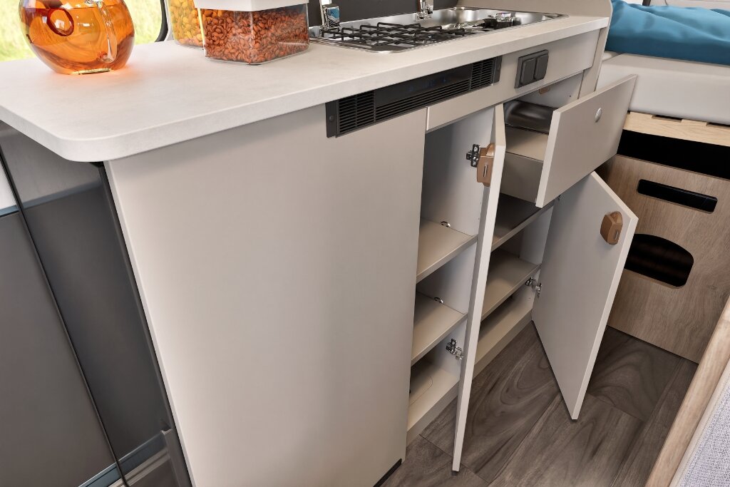 Carado motorhome interior with kitchen unit, open storage space, drawer and gas hob