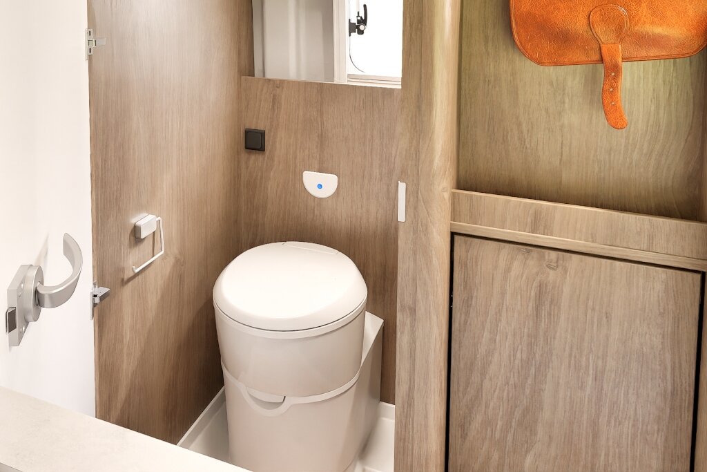 Bathroom in the Carado motorhome with cassette toilet, wood decor and storage space