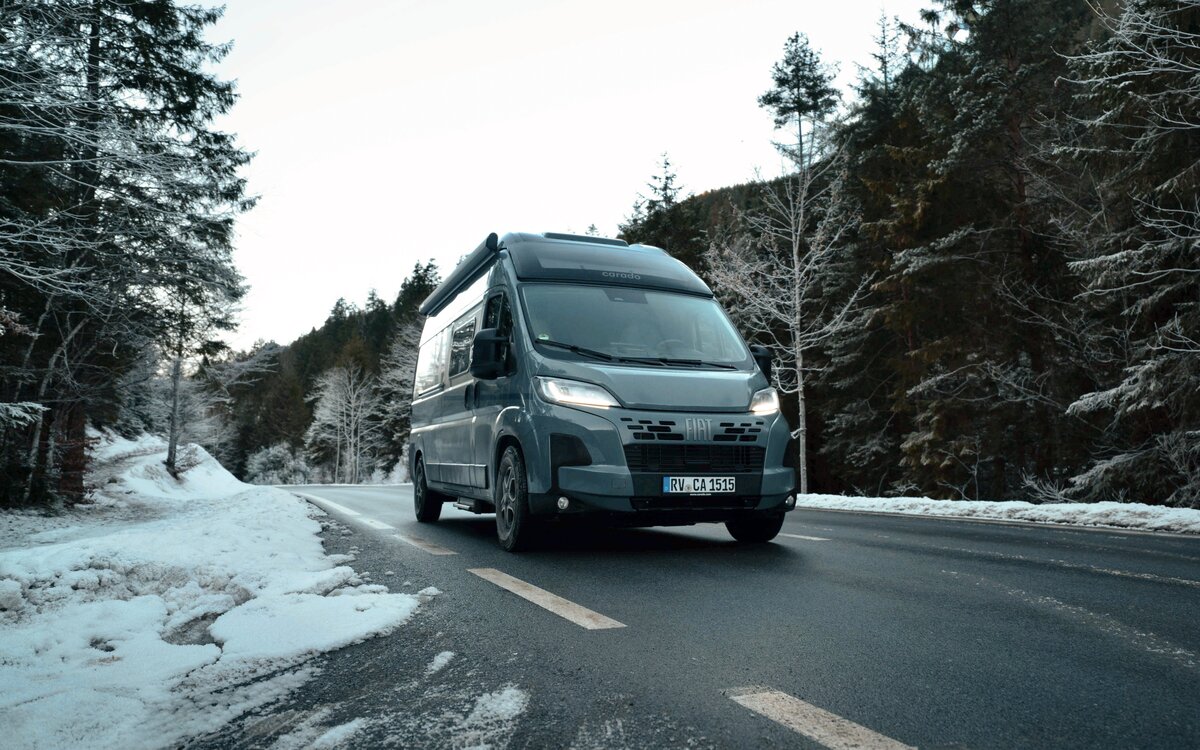 Carado motorhome on a wintery forest road, front view while driving