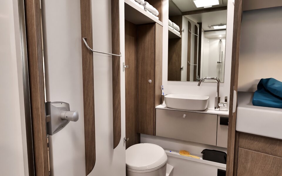 Carado motorhome bathroom with washbasin, toilet, mirror, storage space and shower in the background