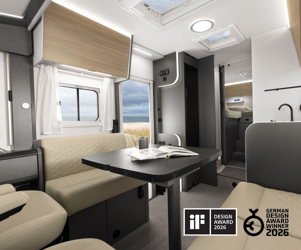 Stilvoll gedeckter Essbereich eines Etrusco Wohnmobils mit floraler Tischdecke und sonniger Aussicht durch die Fenster.