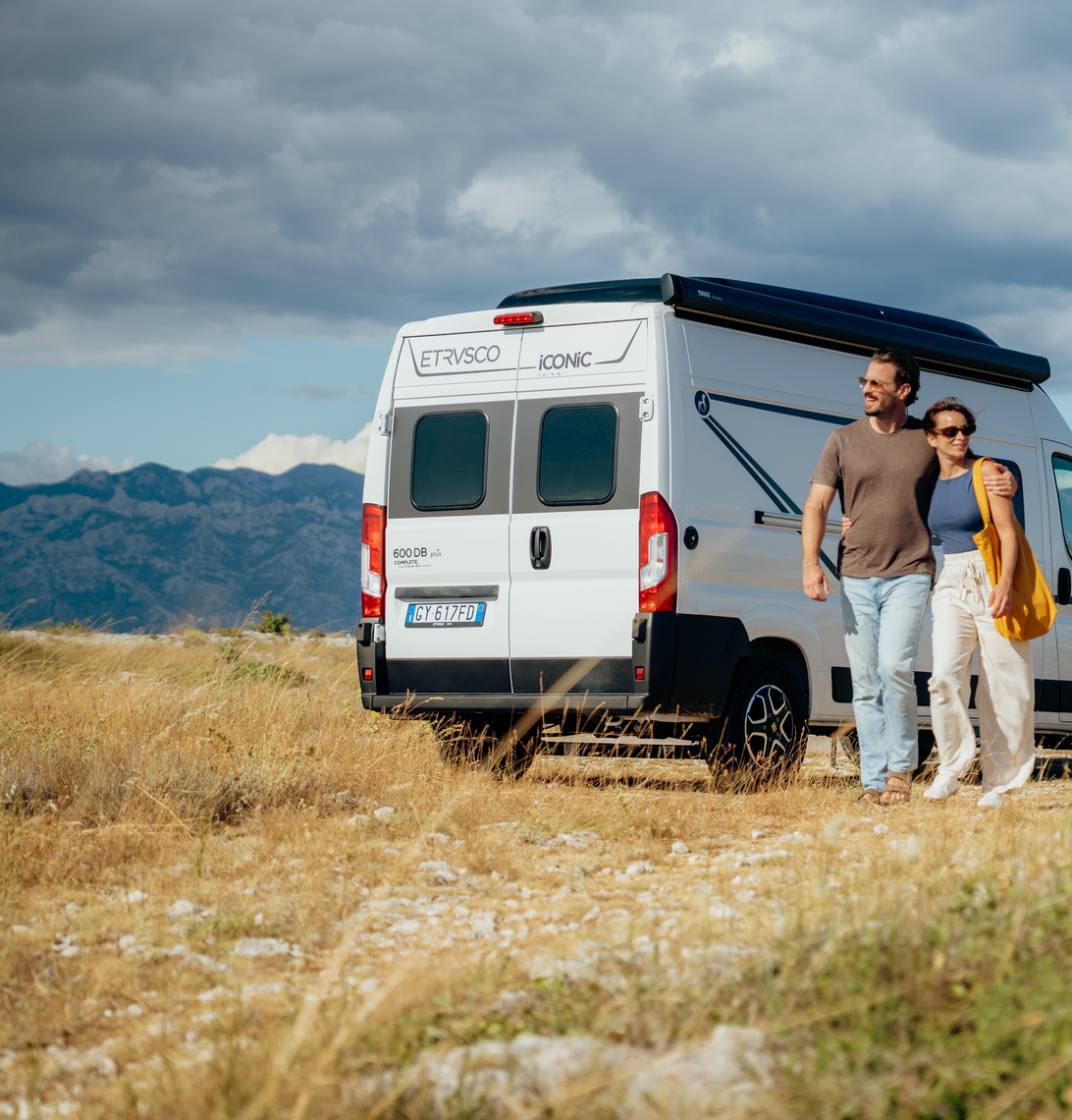 Ein grauer Fiat Campervan von Etrusco mit geöffneter Tür steht in einer trockenen Sommerlandschaft – der ideale Kastenwagen für Offroad-Abenteuer.
