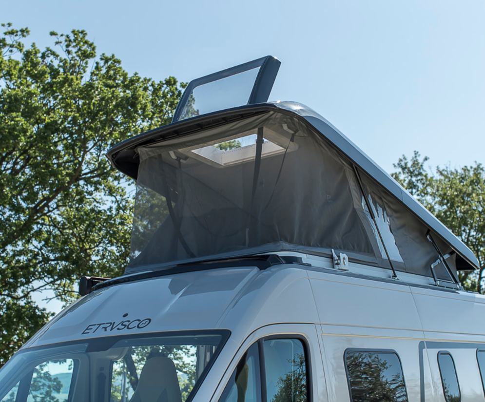 Raised pop-up roof of an Etrusco campervan Fiat with a window, ideal for camping and additional sleeping space.