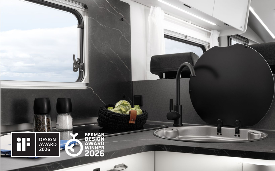 Moderne køkken i Etrusco autocamper med skærebræt, melon, krydderurter og to-blus gaskomfur, ideel til camping.