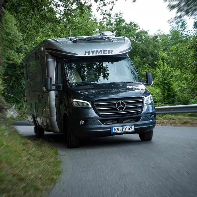 HYMER MasterLine T on a Mercedes chassis driving uphill through a forested road