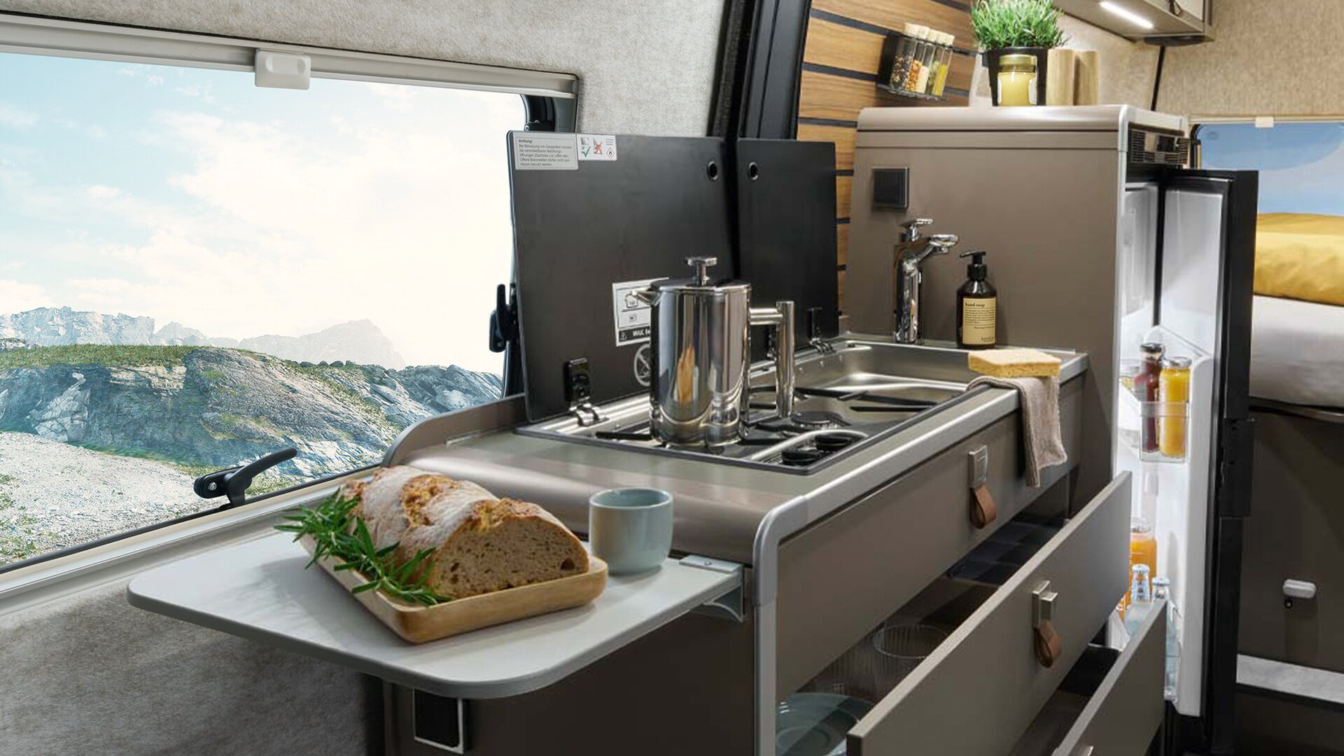 På köksutvidgningen i HYMER Grand Canyon S ligger bröd. I bakgrunden finns köksdelen med spis, diskbänk och kylskåp.