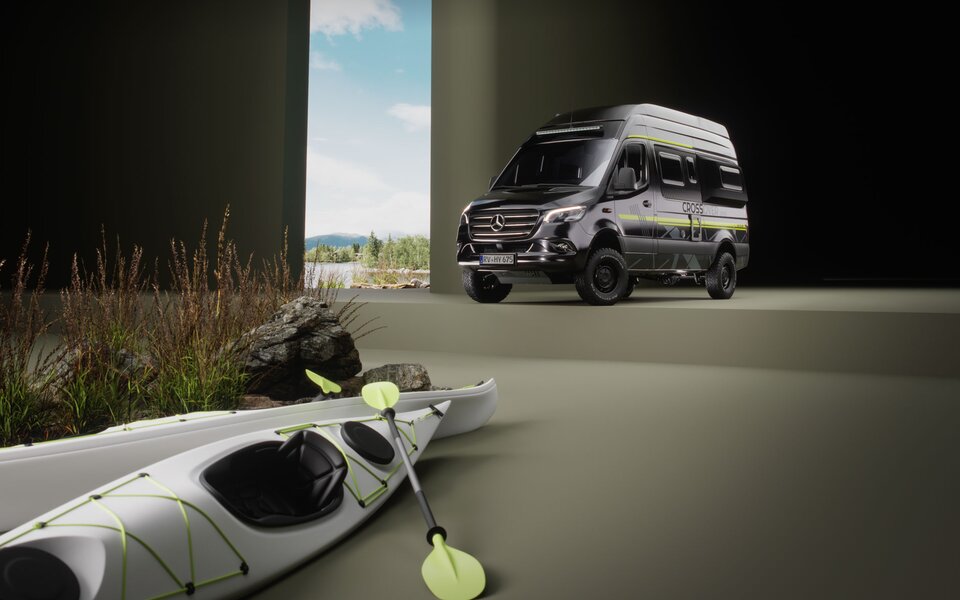 Svart Mercedes-husbil med sportiga dekaler och gröna accenter står i ett rum där ett golv-till-tak-fönster visar ett skogbevuxet sjölandskap. I förgrunden finns två vita kajaker med gröna paddlar bredvid grova stenar och fina gräs.	