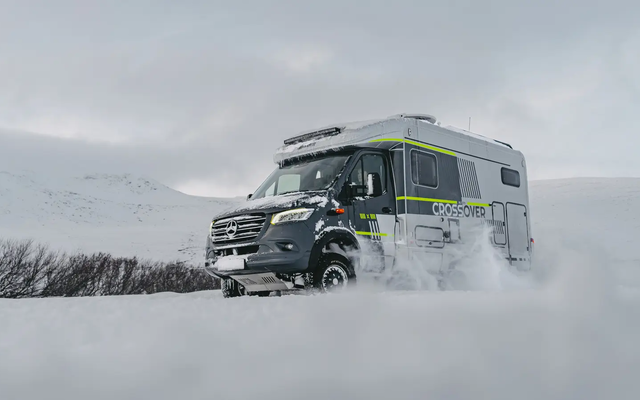 Diagonal view from the front right of the HYMER ML-T 570 CrossOver, driving through a winter snowy landscape